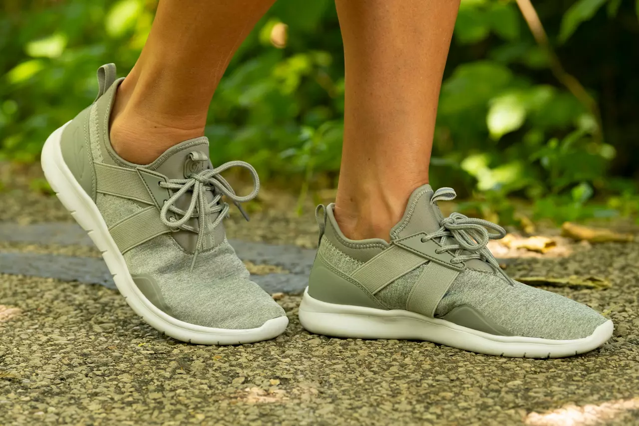 Close-up of woman wearing grey tennis shoes outside